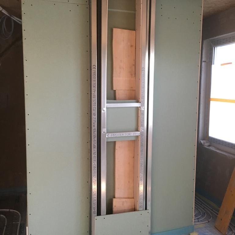 Unvollständig beplankte Wand mit Metallständerwerk und Holzverstrebungen im Innenausbau